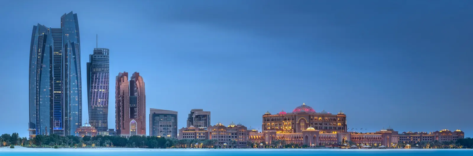 Abu Dhabi seen across the water at dusk, the centre a fund manager is weighing against the DIFC