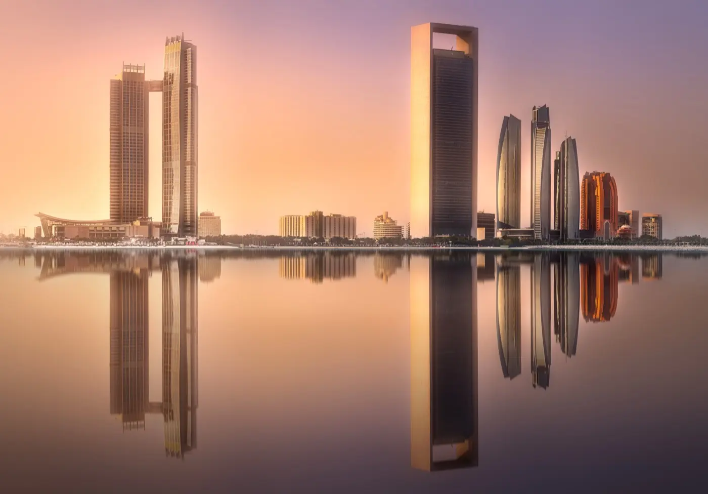 Abu Dhabi towers reflected in still water at sunrise, the centre whose funds framework has been rewritten