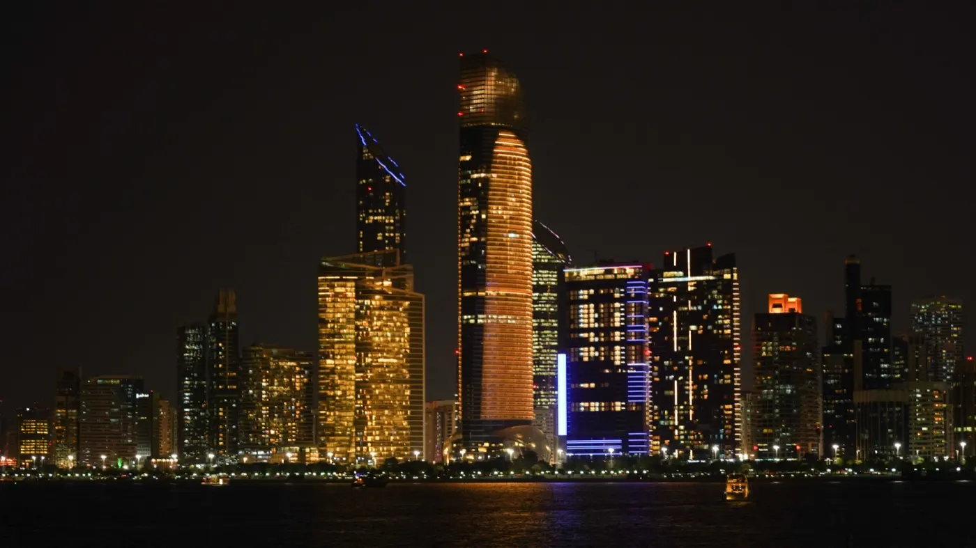 The Abu Dhabi skyline lit at night, where an ADGM holding company is registered