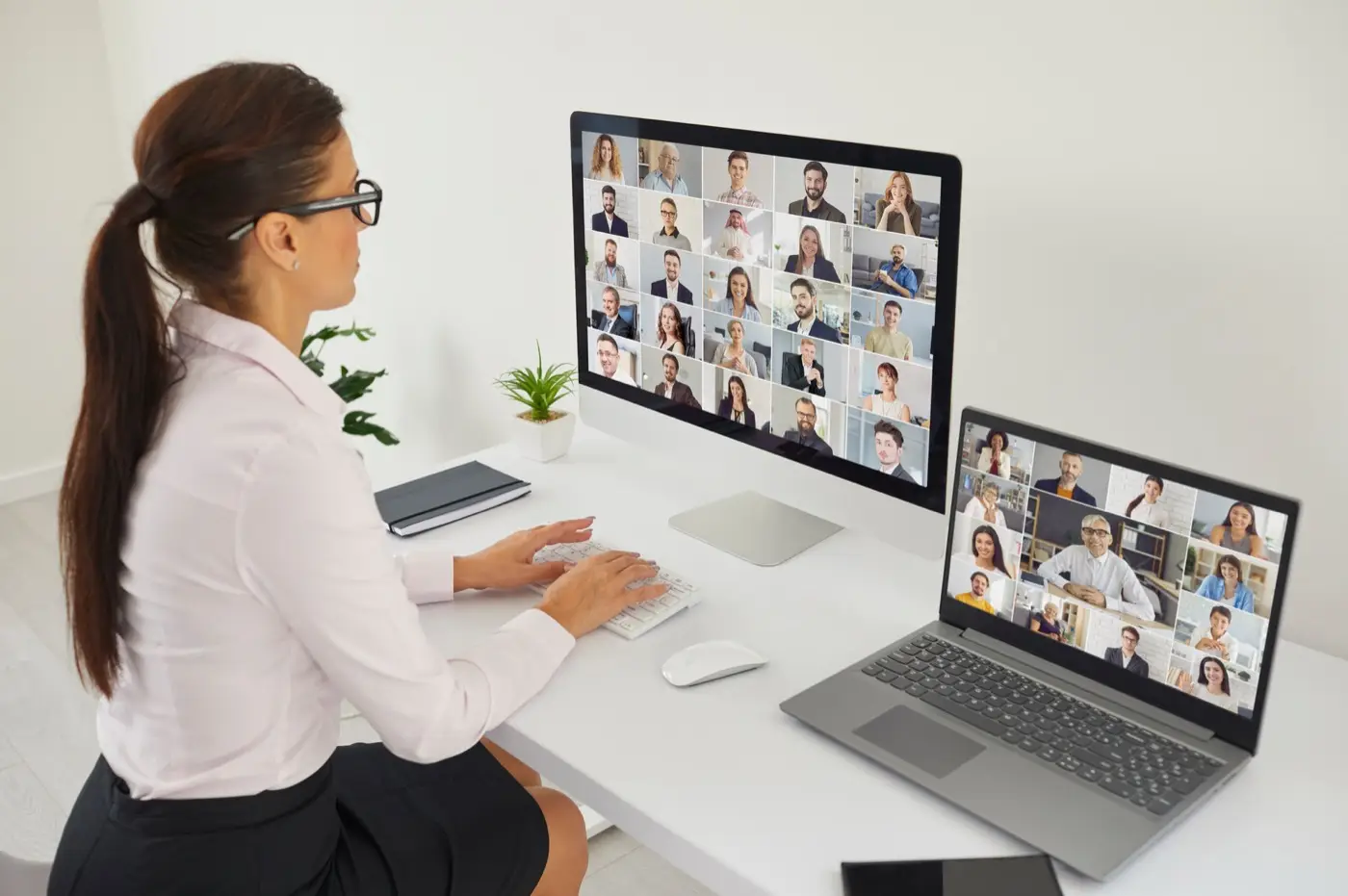 A businesswoman chairing a virtual board meeting across two screens, showing how a DIFC company can be governed from anywhere