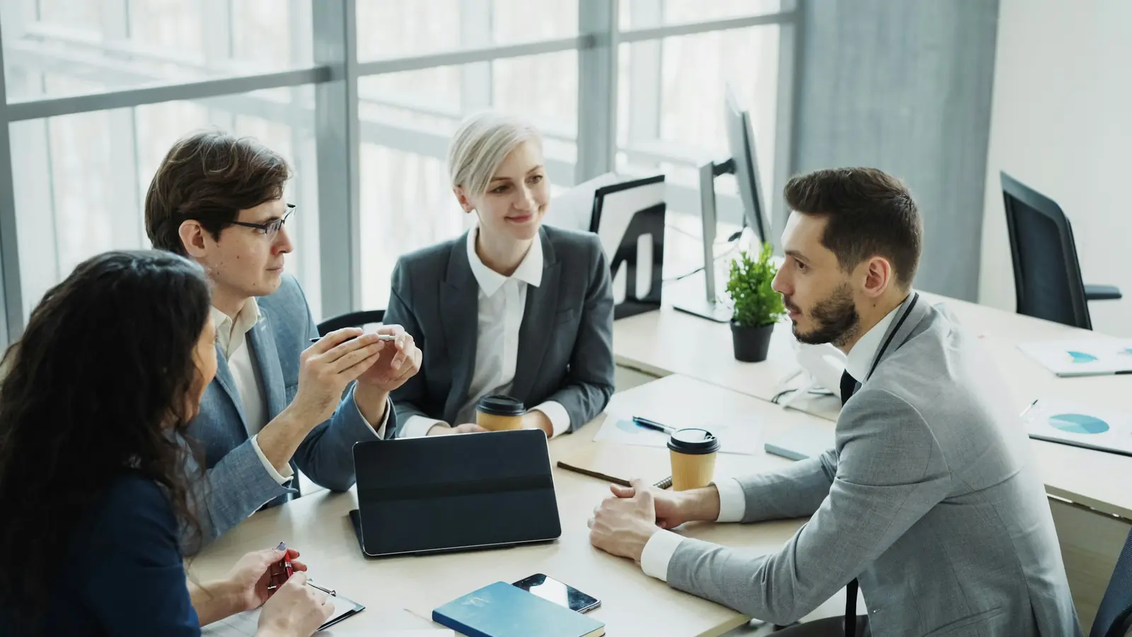 Colleagues meeting in a glass walled office, the workforce a DIFC employer enrols into DEWS