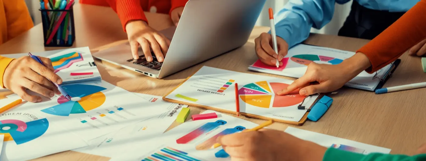 A startup team working over laptops and notes, the stage an innovation licence is designed for