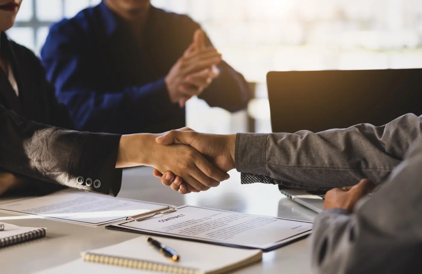 A handshake over signed documents, the point at which a share transfer still has to reach the Registrar
