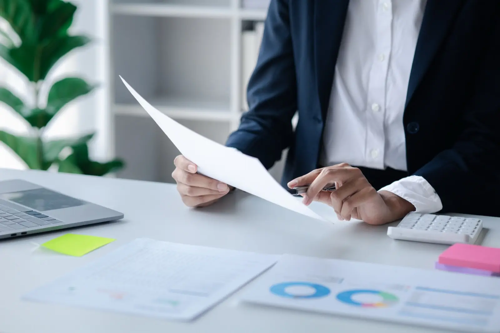 A financier reviewing a fund's statements at a desk, preparing the corporate tax exemption application
