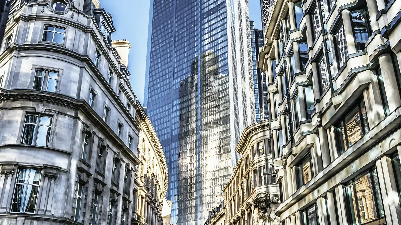 A London street of period buildings below modern towers, the UK assets a DIFC company can hold