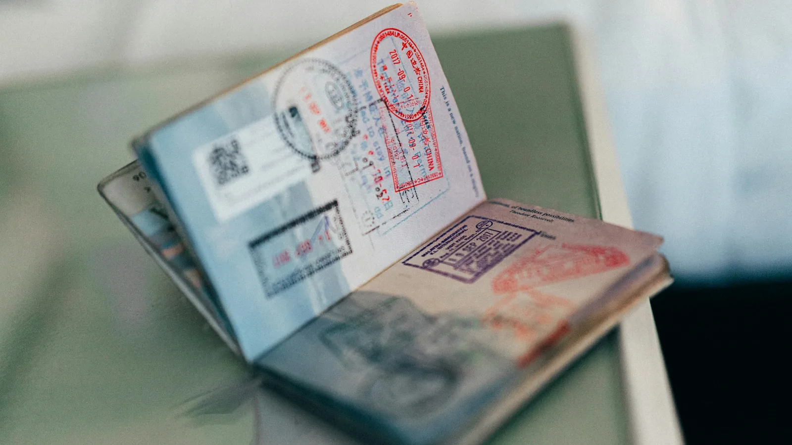 An open passport stamped with entry visas, the record a DIFC residence visa is added to