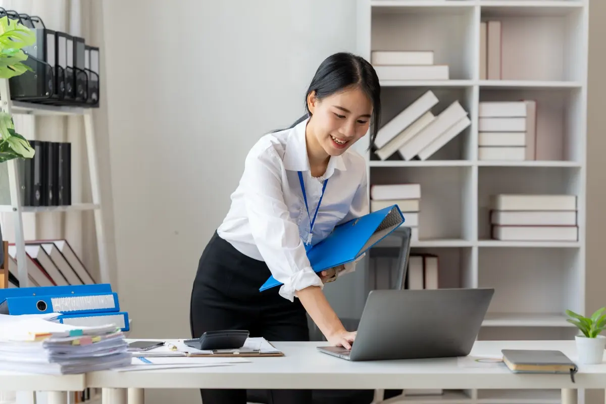 An administrator organising company files in a modern office, the ongoing work an entity needs whatever its type
