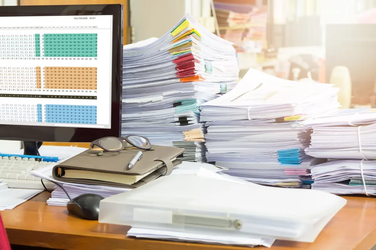 A pile of unfiled paperwork on a desk, what an entity's corporate record looks like when nobody is administering it